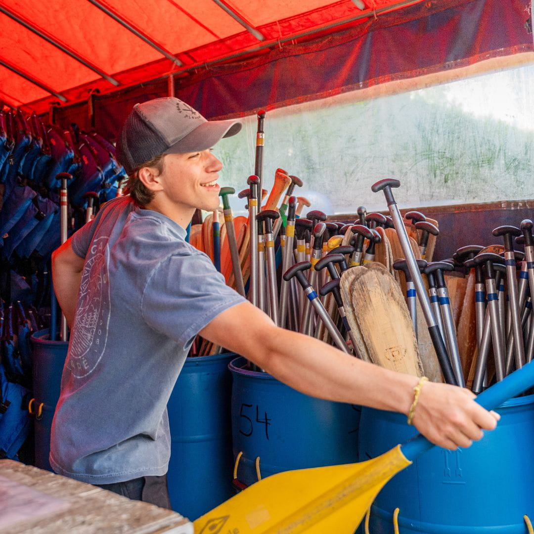 Employé donnant de l'équipement de location chez Canots Légaré Employé souriant donnant de l'équipement de location chez Canots Légaré